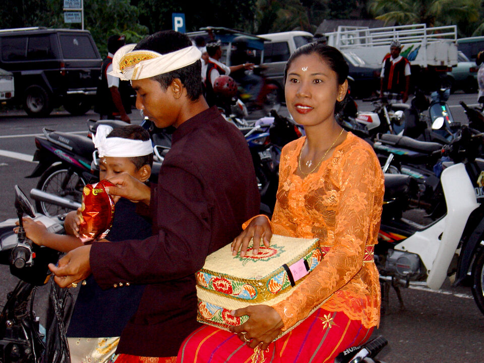 Familie fährt with dem Moped zur temple ceremony
